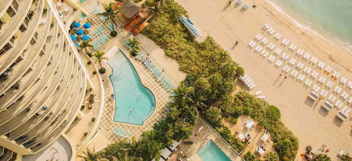 Aerial view of hotel pools and tropical beach