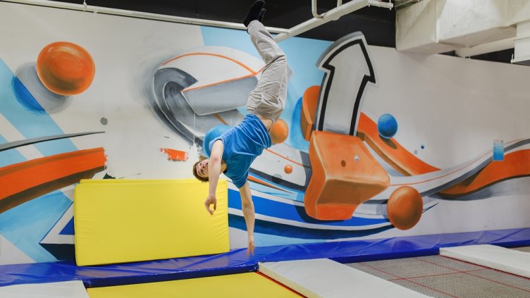 A young man doing fly stunts in trampoline park; Shutterstock ID 558997459