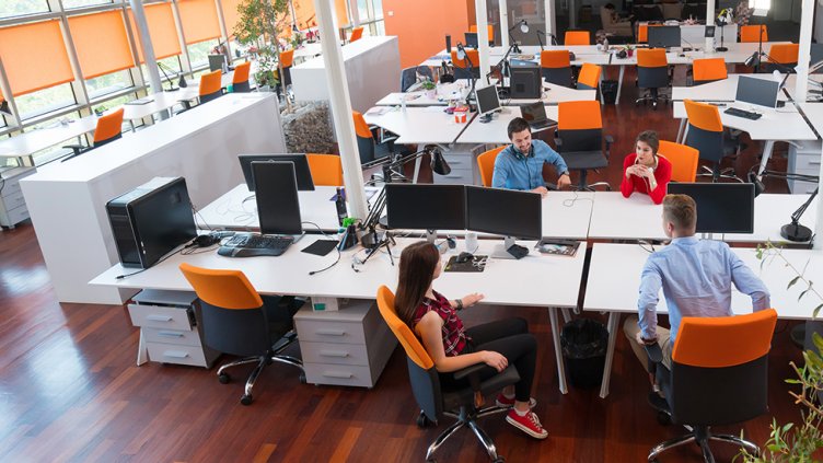four tech workers in an open office space